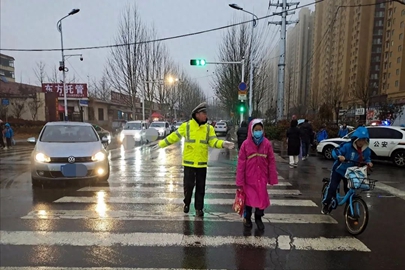 临沂市郯城交警：雨中坚守护学岗 撑起学生“平安伞”